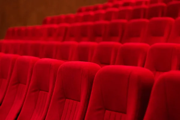 Empty cinema hall with red seats.