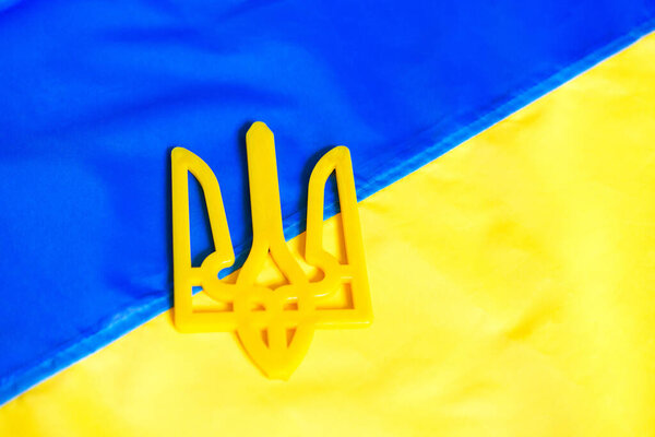 The flag of Ukraine on which the coat of arms is depicted. Texture flag of Ukraine. Ukrainian symbols. War 2022.