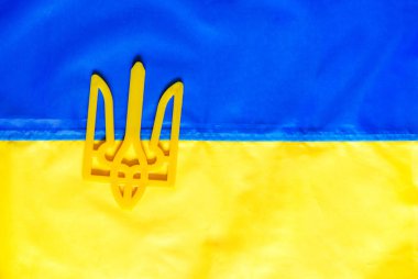  Üzerinde silah ceketi tasvir edilen Ukrayna bayrağı. Yakın plan. Ukrayna 'nın doku bayrağı. Ukrayna sembolleri. Savaş 2022.