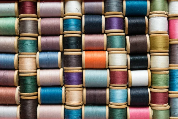 Multi-colored spools of thread close-up. Sewing threads multicolored background closeup