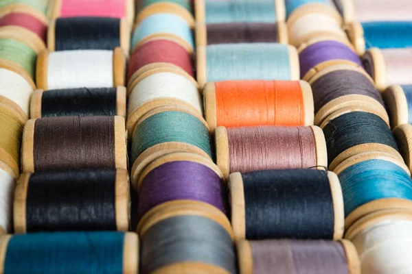 Multi-colored spools of thread close-up. Sewing threads multicolored background closeup