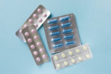 Mavi arka planda haplarla su toplamış. Reklam, web geçmişi ya da diğer fikirler olarak sunulan özel modeller. İlaç, eczane ve sağlık hizmetleri kavramı. telif hakkı.