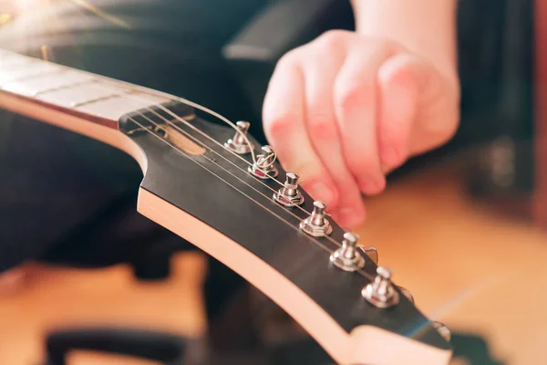 Changing strings on an electric guitar. Music theme.