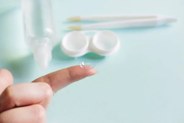 Women\'s hands with contact lenses and a container for contact lenses.   Medicine and vision concept