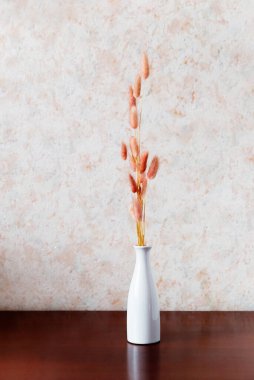 vase and flowers on a wooden table on a light background. Interior detail. Minimalism.