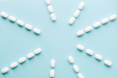 white pills on blue table. Medical, pharmacy and healthcare concept. Copy space.  Place for text or logo. Mock up for special offers as advertising or other ideas.