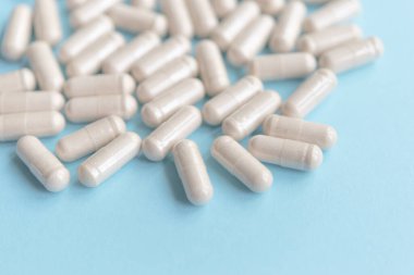 white pills on blue table. Medical, pharmacy and healthcare concept. Copy space.  Place for text or logo. Mock up for special offers as advertising or other ideas.