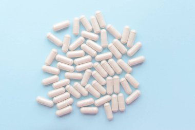 white pills on blue table. Medical, pharmacy and healthcare concept. Copy space.  Place for text or logo. Mock up for special offers as advertising or other ideas.