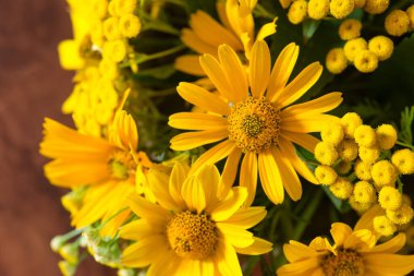 Bouquet of bright different yellow flowers on a table