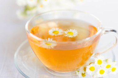 Papatya çiçekli bir fincan bitki çayı.