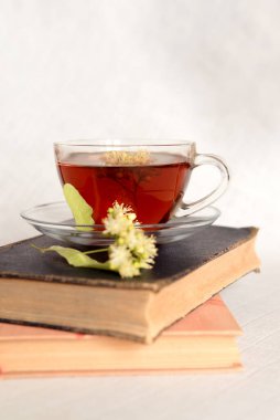 Hafif pastel arka planda ıhlamur çiçeği çayı. Eski kitaplar. Boşluğu kopyala