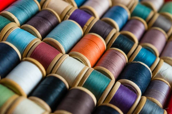 Multi-colored spools of thread close-up. Sewing threads multicolored background closeup