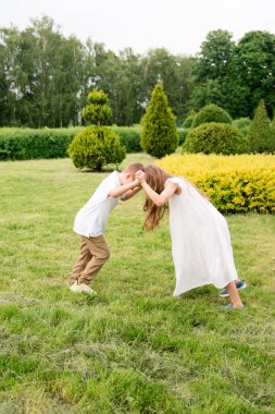 Cheerful children in nature. Brother and sister play and play. Happy childhood.