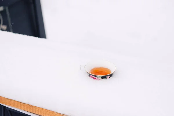 雪の上にカップで冬のお茶 自然の中でコーヒーと冬の大気の背景 晴れた霜の朝 — ストック写真