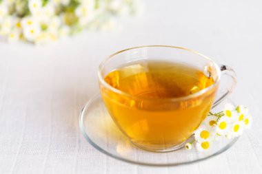 Papatya çiçekli bir fincan bitki çayı.