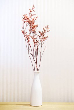 vase and flowers on a wooden table on a light background. Interior detail. Minimalism.