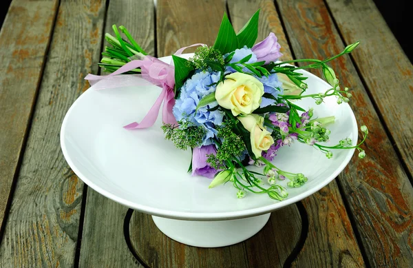 Bouquet of flowers on a white dish — Stock Photo, Image