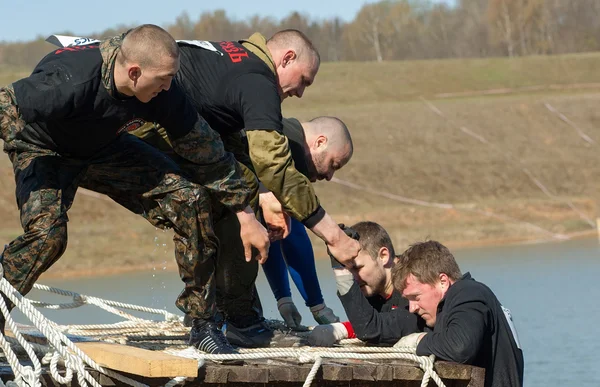 Men climb on wood tower