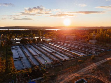 Modern atık su arıtma tesisi, atık su arıtma tankları, akşam günbatımında hava manzarası..