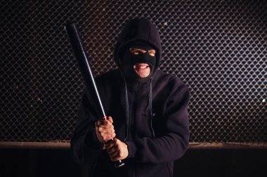 Sopalı maskeli kızgın adam. Serseri konsepti.