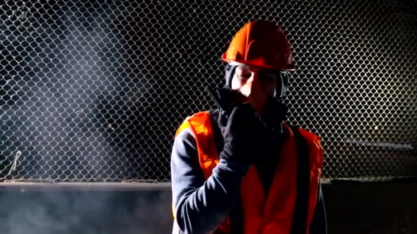 Man met masker in gesprek op walkie-talkie tijdens brand in industrieel gebouw — Stockvideo