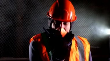 Endüstriyel binadaki yangın sırasında solunum cihazındaki adam telsizle konuşuyor.