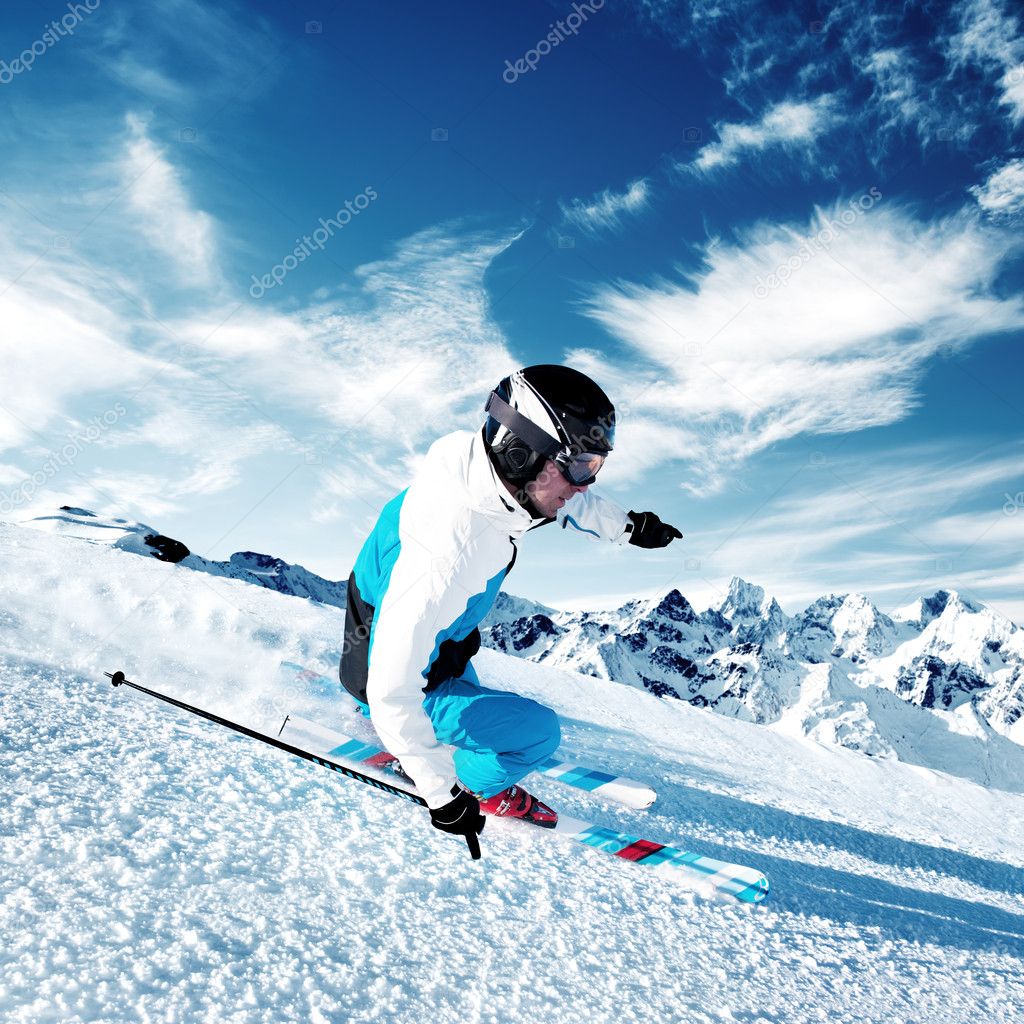 Skier in mountains, prepared piste and sunny day