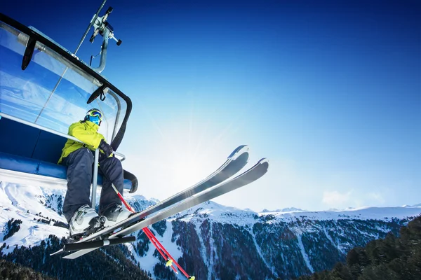 Esquiador situado en el telesilla - ascensor en el día soleado y la montaña —  Fotos de Stock