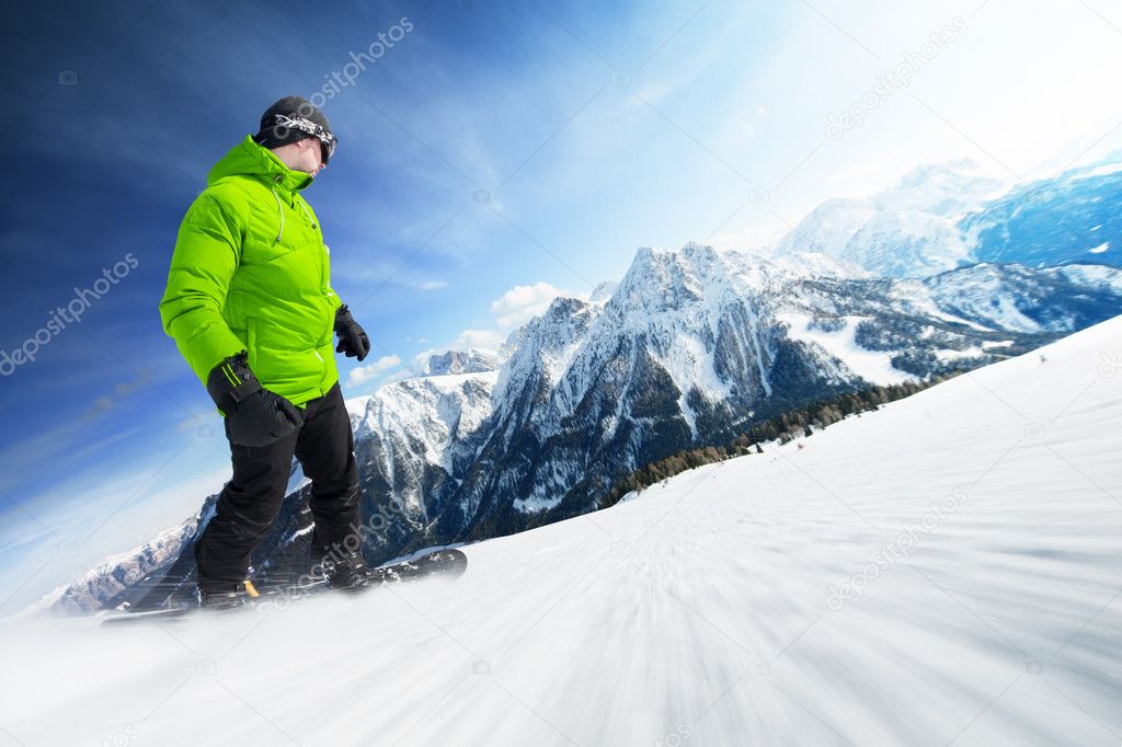 Snowboarder on piste in high mountains