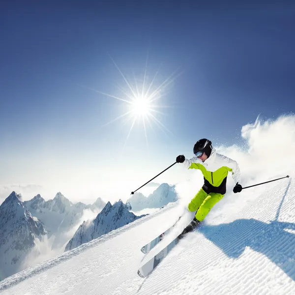 Skiër in Bergen, bereid piste en zonnige dag — Stockfoto