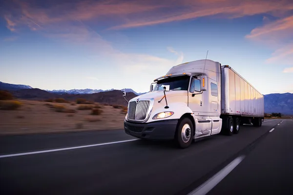 Camion e autostrada al tramonto - sfondo trasporto Immagine Stock