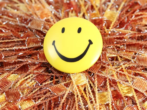 Yellow smile button on brown thread background — Stock Photo, Image