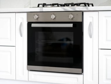Gaz ile soba ve yepyeni modern beyaz mutfak, elektrikli fırın gömülü