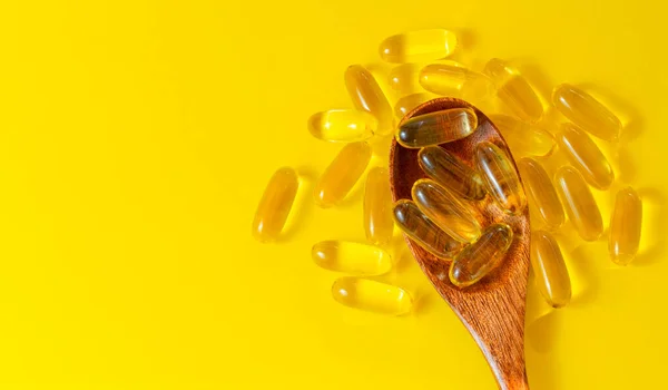 Sarı Arka Planda Omega Haplı Tahta Kaşık Vitamini Kapsülleri — Stok fotoğraf