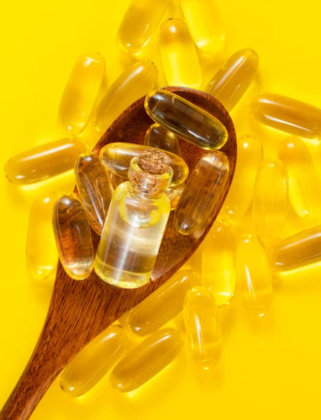 Sarı Arka Planda Omega Haplı Tahta Kaşık Vitamini Kapsülleri — Stok fotoğraf
