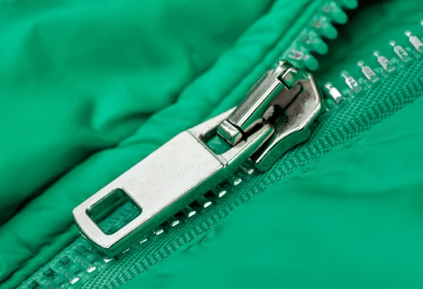 Dikişleri, metal düğmesi ve fermuarı açık fermuarı olan su geçirmez kumaştan yapılmış yeşil bir ceket parçası..