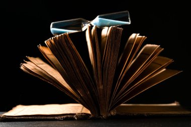 Siyah arkaplanda saat ve İncil aç