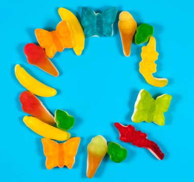 Sweet gummy candies on a blue background