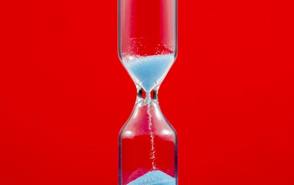 赤い背景の砂時計マクロ — ストック写真