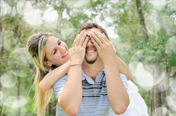 微笑女孩覆盖她男朋友的眼睛 — 图库照片