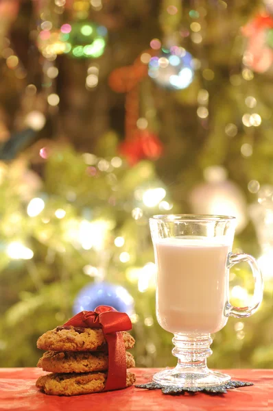 Vaso de leche con galletas bajo el árbol de Navidad —  Fotos de Stock