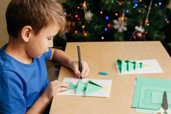 Kind bastelt Weihnachtskarte aus Papier. Schritt 7 — Stockfoto