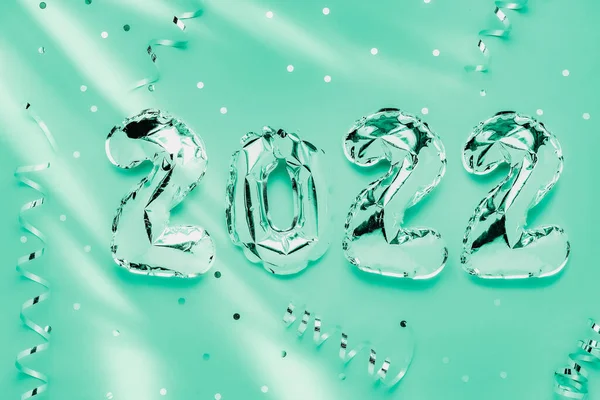 Balon foil dalam bentuk angka 2022 pada latar belakang hijau — Stok Foto