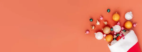 Dekorasi Natal jatuh dari topi santa di latar belakang oranye — Stok Foto