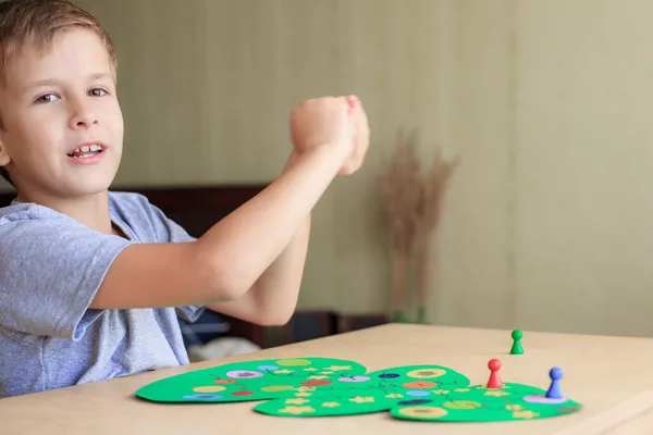 Kind würfelt und schiebt den Chip über das Weihnachtsspielfeld Stockbild