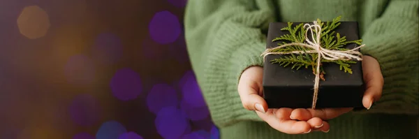 Női kéz kezében szép ajándék doboz, blured bokeh fény a háttérben. — Stock Fotó