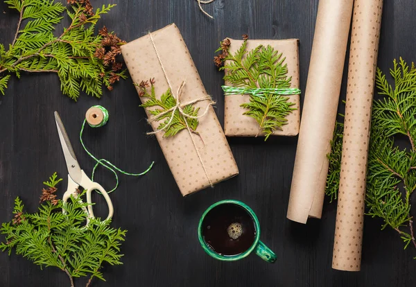 Regalos de Navidad envueltos en papel artesanal y taza de café negro —  Fotos de Stock