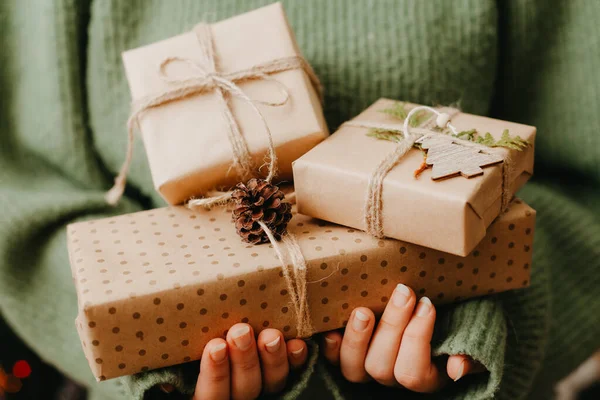 Les mains des femmes en pull tenant de nombreuses boîtes-cadeaux. — Photo