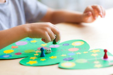 çocuk eli zarı atar ve çipi Noel oyun sahasında hareket ettirir