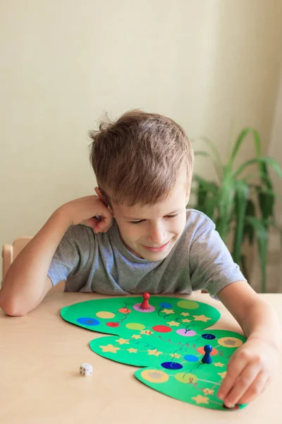Anak menggulung dadu dan bergerak chip di seluruh lapangan Natal bermain — Stok Foto